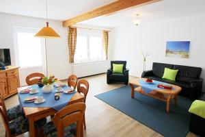 a living room with a table and a couch at Meeresblick Fehmarn Ferienhaus 42 in Fehmarn