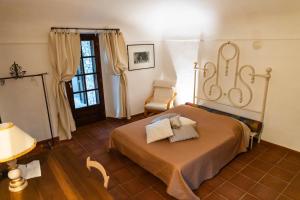 1 dormitorio con 1 cama, 1 silla y 1 ventana en Agriturismo La Verena, en Vesime