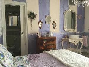 een slaapkamer met paarse muren, een wastafel en een bed bij La maison delle favole in Desenzano del Garda