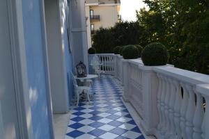 einen Balkon mit weißen Zäunen und blauen und weißen Fliesen in der Unterkunft La maison delle favole in Desenzano del Garda