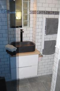 baño con lavabo marrón y espejo en La petite Piaule - 132, en Rouen