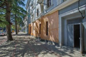 an empty street with a tree and a building at Apartment Anano in Kutaisi