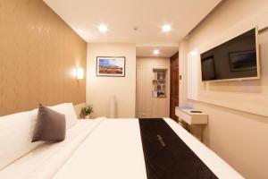 een hotelkamer met een groot bed en een flatscreen-tv bij Silent Night Dem Lanh Hotel in Da Lat