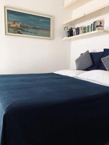 a bedroom with a bed with a blue blanket at Casa con vista a Numana in Numana
