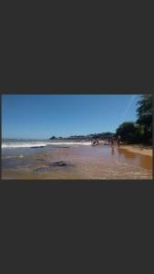 a view of a beach with people in the water at Casa quadra praia Jacaraipe! in Jacaraípe