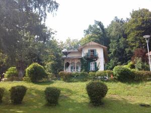 a white house with a balcony in a yard at Villa Margarethe in Reifnitz