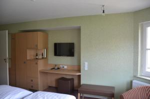 a hotel room with a bed and a tv on the wall at Hotel Ortel in Besigheim