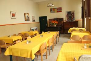 ウィーンにあるポルツラヌウムの黄色のテーブルと椅子、ピアノのあるレストラン
