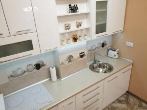 a kitchen with white cabinets and a sink at Apartment Centar Exclusive Smederevo in Smederevo +35 photos