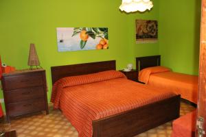 1 dormitorio con 2 camas y paredes verdes en Estate4Home - Orange Dreams en Sant'Agnello
