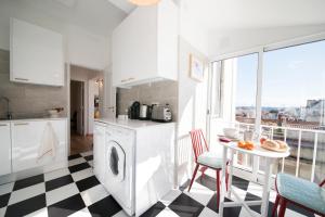 una cucina bianca con pavimento a scacchi di Light Lovers Apartment a Lisbona