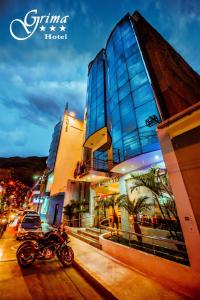 瓦努科Grima Hotel的停在大楼前的街道上的摩托车