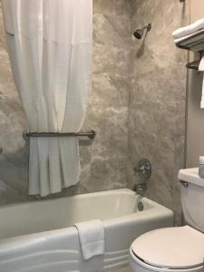 a bathroom with a white tub and a toilet at Days Inn by Wyndham Grove in Grove