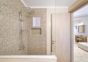 a bathroom with a shower with a glass door at Kapsogeorgis Rooms in Koinyra