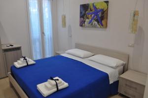 Un dormitorio con una cama azul con toallas. en B&B degli Aranci, en Palinuro