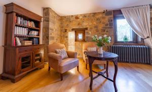 a living room with a chair and a table at Hotel Rural El Pandal in Ardisana