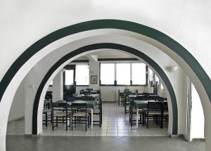 un arco con mesas y sillas en un restaurante en Hotel Helios, en Paralia Katerinis