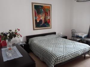 1 dormitorio con 1 cama y una pintura en la pared en Il Ciclamino, en Alberobello