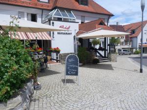 una calle con un restaurante y un cartel frente a un edificio en Hotel Ortel, en Besigheim