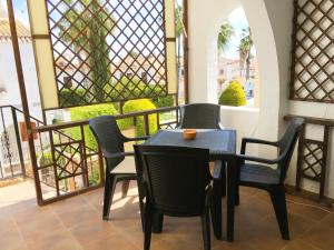 a table and chairs on a balcony with windows at Apartment Quesada in Ciudad Quesada