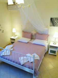a bedroom with a large bed with two lamps at Themis Apartments in Sami