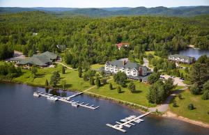 una vista aérea de una gran casa en un lago en Auberge du Lac-à-l'Eau-Claire en Saint-Alexis-des-Monts