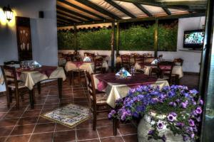 un restaurante con mesas, sillas y flores púrpuras en Villa Fiori Beach, en Menfi