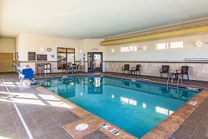 a large swimming pool with chairs and tables in a building at Sleep Inn & Suites West-Near Medical Center in Rochester