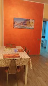 einen Tisch mit Stühlen und ein Gemälde an der Wand in der Unterkunft La rosa dei venti in Legnano