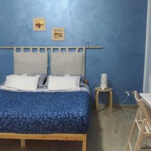 Schlafzimmer mit einem Bett mit blauer Wand in der Unterkunft La rosa dei venti in Legnano