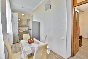 a kitchen and dining room with a table and a refrigerator at Apartment Anano in Kutaisi