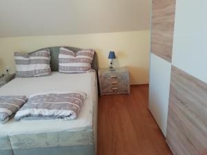 シオーフォクにあるEdit Ferienwohnung Siofokのベッドルーム(枕付きのベッド、ナイトスタンド付)