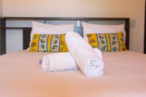 a pile of towels sitting on top of a bed at Flat's Portal do Sol-SMG in São Miguel do Gostoso