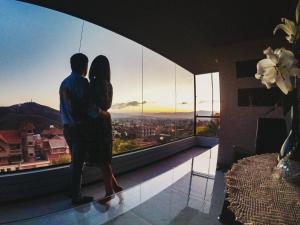 un hombre y una mujer de pie en un balcón con vistas a la ciudad en Las vistas - Departamento independiente, en Cochabamba