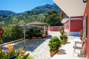 een binnenplaats van een huis met een paraplu en planten bij Villa Levante in Vasilikos