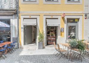 um grupo de mesas e cadeiras em frente a um edifício em Oporto Street Sá de Noronha no Porto