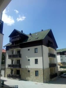a large white building with a black roof at Apartment Marjana in Zlatibor