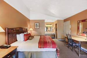Headwaters Lodge & Cabins at Flagg Ranch في موران: غرفة في الفندق بها سرير ومكتب ومكتب