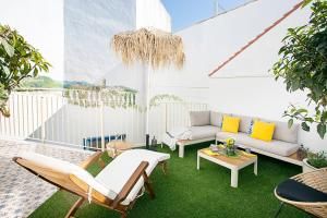 a patio with a couch and chairs on a balcony at Graffiti Suites Málaga in Málaga
