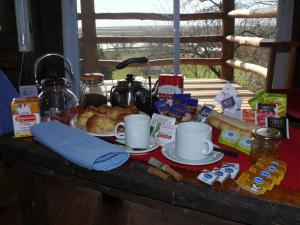 una mesa con desayuno y café. en Cabañas de la Ribera en San Pedro