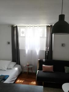 ein Wohnzimmer mit einem Sofa und einem Fenster in der Unterkunft STUDIO BIARRITZ in Biarritz