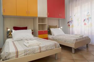 two beds in a room with colorful cabinets at Panorama Host - Domus Amalfi Coast in Maiori +51 photos