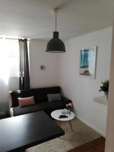 ein Wohnzimmer mit einem schwarzen Sofa und einem Tisch in der Unterkunft STUDIO BIARRITZ in Biarritz