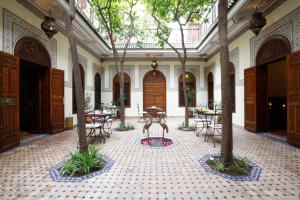 une cour avec des tables et des chaises et une statue de girafe dans l'établissement Riad Daria Suites & Spa, à Marrakech