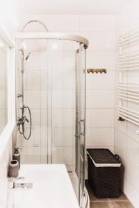 baño blanco con ducha y lavamanos en Apartament w centrum Olsztyna - Grunwaldzka, en Olsztyn