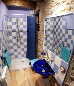 La salle de bains est pourvue d'un lavabo bleu et d'une douche. dans l'établissement Cal Sams, à Olopte