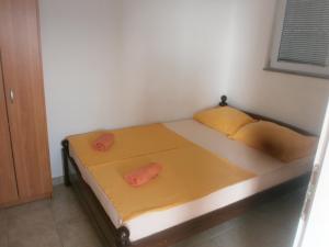 a bed in a room with two orange pillows on it at APARTMANI LAŠTRO in Jesenice