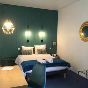 A bed or beds in a room at Hôtel Aux Vendanges de Bourgogne