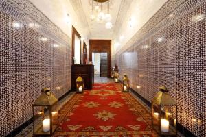 un couloir avec des lumières et un tapis rouge ainsi qu'une chambre dans l'établissement Riad Daria Suites & Spa, à Marrakech