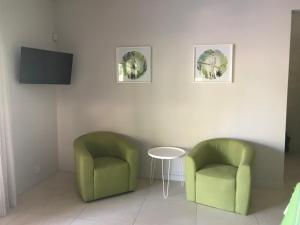 2 sillas verdes y una mesa en una habitación en Casa Papito, en Potrero